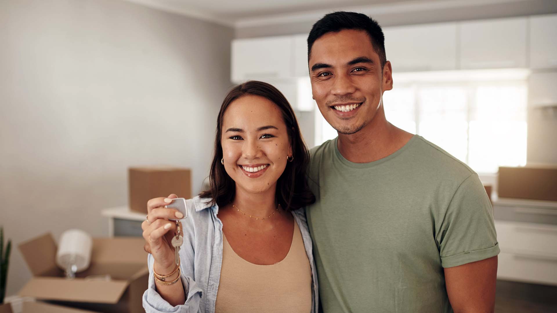 Couple holding up the house key to their new home