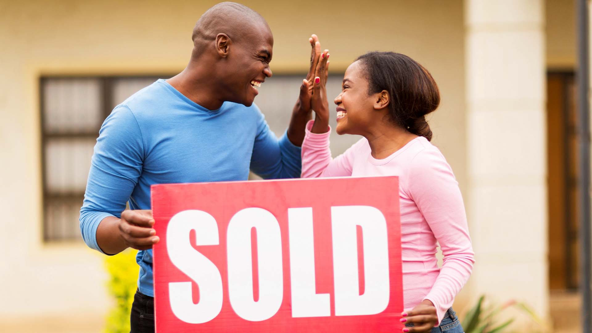 Young couple celebrating their home has been sold